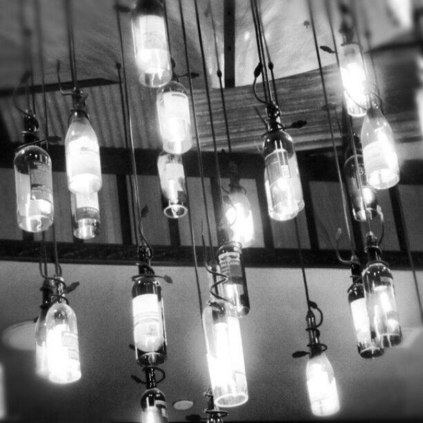 indoors, lighting equipment, hanging, electricity, still life, illuminated, glass - material, close-up, table, in a row, wineglass, no people, light bulb, bottle, arrangement, home interior, ceiling, transparent, electric lamp, empty