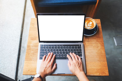 Cropped hands using laptop on table