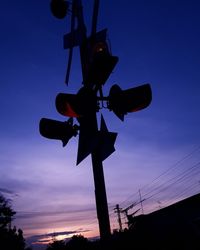 Low angle view of silhouette signal against sky during sunset