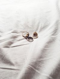 High angle view of rings on white sheet