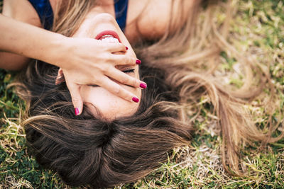 High angle view of smiling woman lying on grass