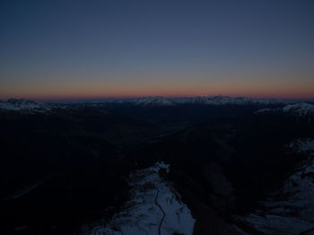 Scenic view of snowcapped mountains against clear sky during sunset