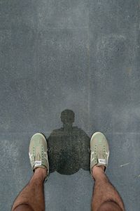 Low section of man standing on wet road