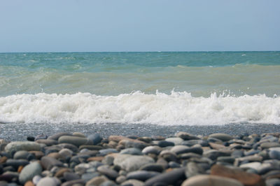 Surface level of stones on beach against sky