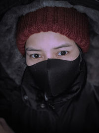 Portrait of mature woman covering face with hat