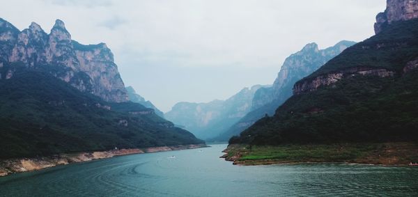 Scenic view of river amidst mountains against sky