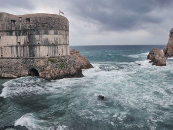 Scenic view of rocks in sea against sky