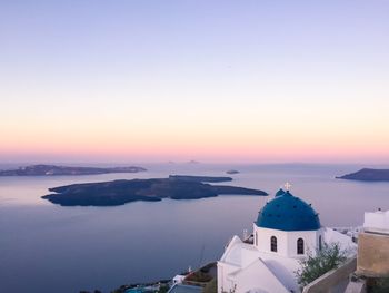 Panoramic view of sea and buildings against sky during sunset