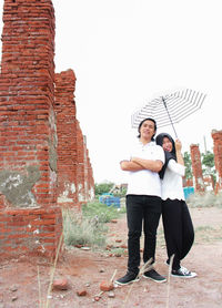 Full length portrait of young couple standing outdoors