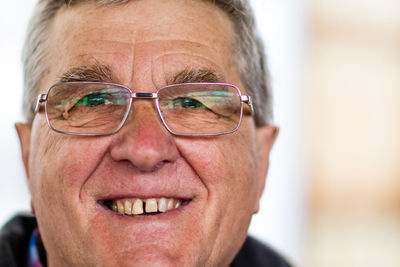 Close-up portrait of smiling senior man wearing eyeglasses