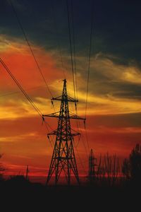 Low angle view of electricity pylon against cloudy sky