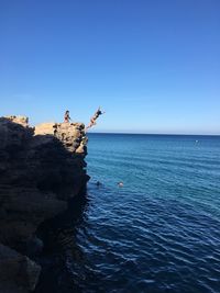 Woman diving in sea against sky