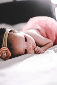 Close-up of baby lying on bed