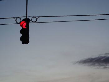 Low angle view of stoplight against sky
