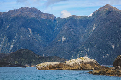 Scenic view of sea and mountains against sky