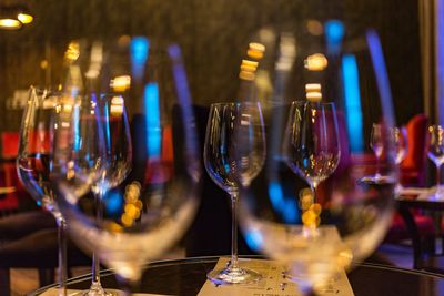 Empty wineglasses on table in illuminated restaurant