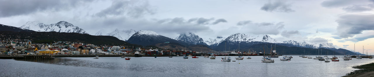 Panoramic view of people on snowcapped mountains against sky