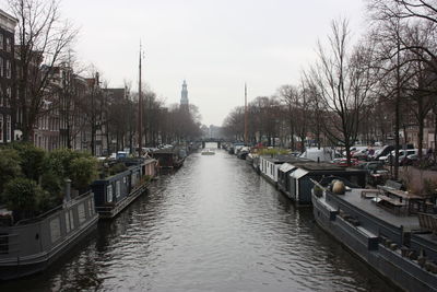 Canal amidst buildings in city against sky