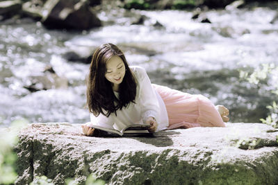 Young woman sitting on rock