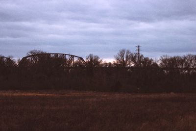 Scenic view of field against cloudy sky