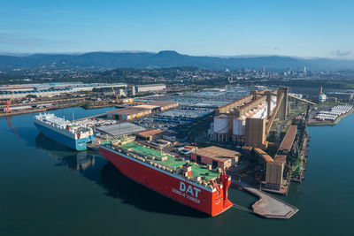 High angle view of commercial dock by city against sky