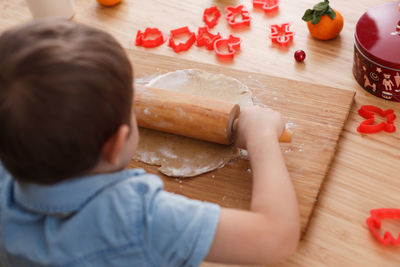 High angle view of boy preparing food on cutting board