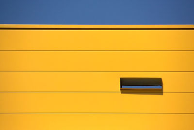 Low angle view of orange building against clear sky