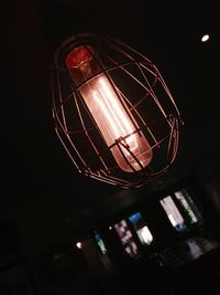 Low angle view of illuminated light bulb against black background