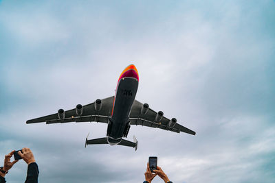 Low angle view of airplane flying against sky