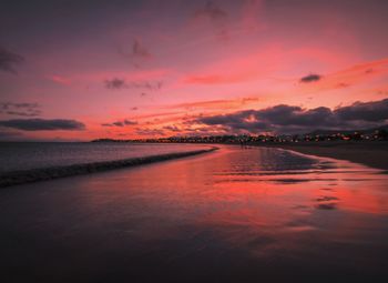 Scenic view of sea against dramatic sky during sunset