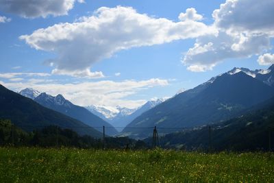 Scenic view of field and mountains against sky