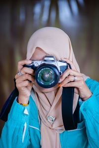 Portrait of woman holding camera