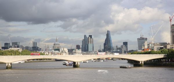 View of waterloo bridge on thames river against city skyline