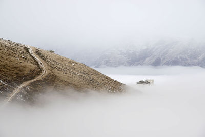 Scenic view of sea of clouds and an house as island against sky