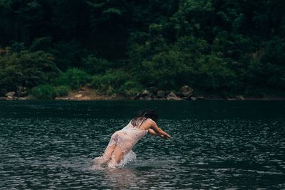 Woman splashing water in lake