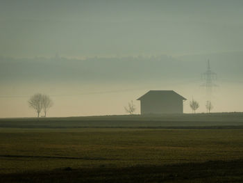 Barn on field against sky