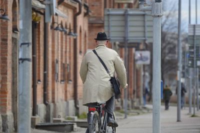 Rear view of man riding bicycle on street