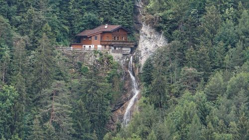 Panoramic view of trees and houses in forest with waterfall