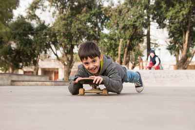 Full length portrait of boy sitting in park