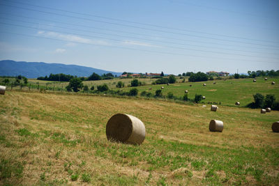 Hay bales on field against sky