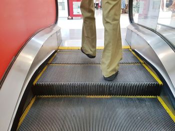 Low section of man standing on escalator