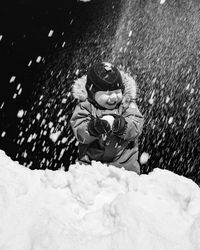 Little boy playing snowballs.