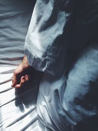 Cropped image of person resting on bed