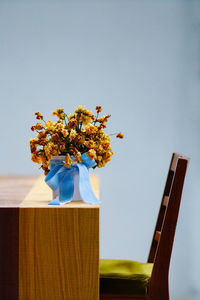 Close-up of flower vase on table against sky