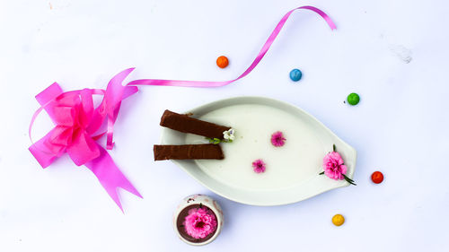 High angle view of pink petals on white background