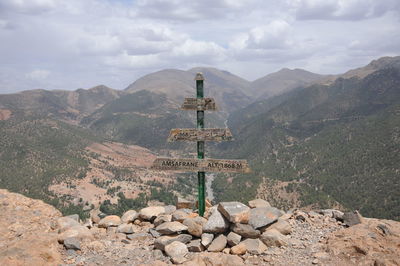 Cross on rock against sky