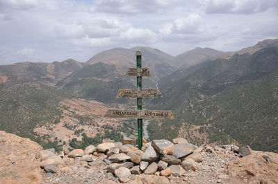 Cross on rock against sky