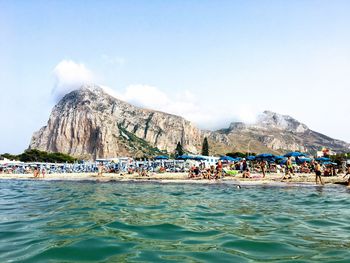 People at beach against sky