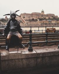 Statue against building in city