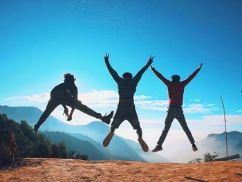 Low angle view of man jumping against sky